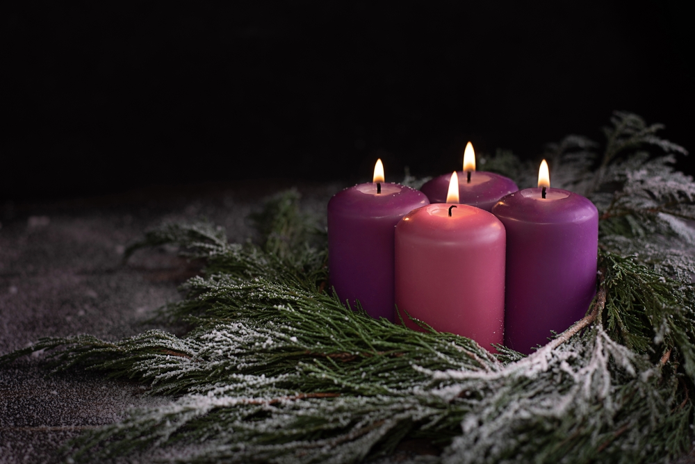snowy,wreath,with,four,burning,purple,advent,candles,on,a