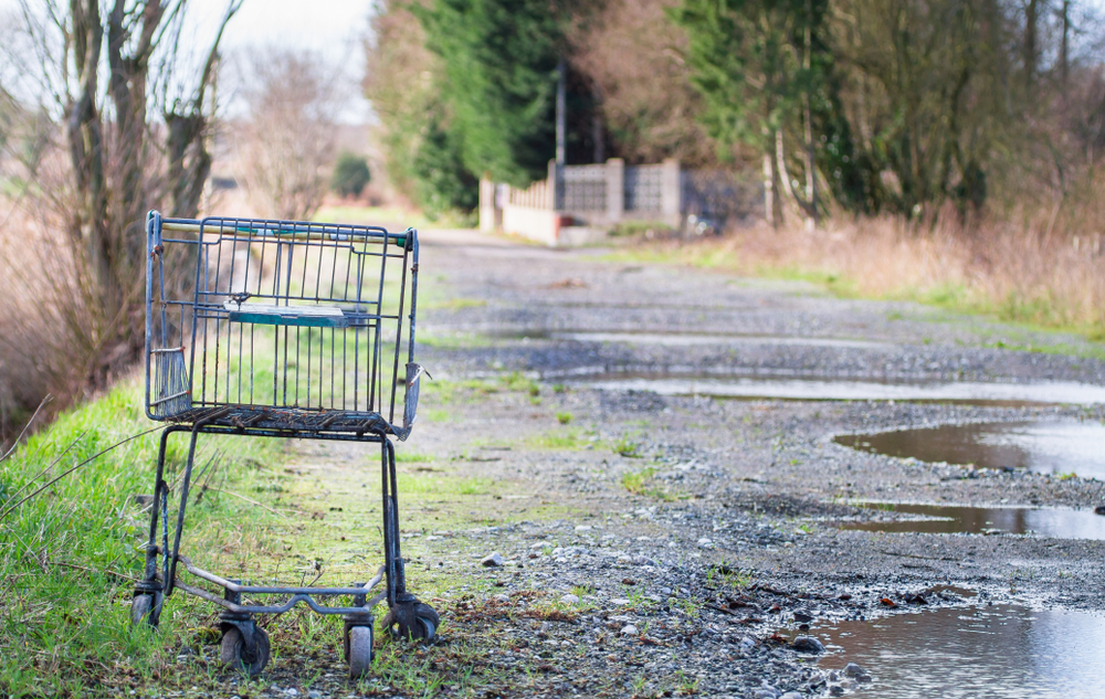 an,old,shopping,cart/trolley,sits,on,a,gravel,road,outside an,old,shopping,cart/trolley,sits,on,a,gravel,road,outside